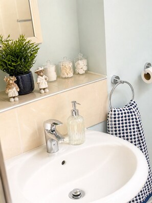 Secadora de cabello, toallas, jabón, papel de baño 