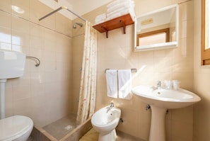 A bathroom with a toilet, bidet, sink, shower with a curtain, and a towel rack. - San Michele - B&B 21 with Veranda, Wi-Fi and Air Conditioning (Mattinata)