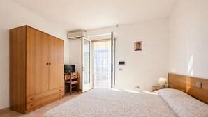 A bedroom with a large bed, a wardrobe, a desk, and a chair. - San Michele - 23 - Bed & Breakfast with Sea View, Wi-Fi and Air Conditioning (Mattinata)