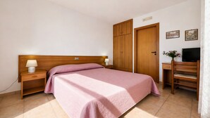 A bedroom with a bed, nightstands, a wooden wardrobe, a desk, and a television. - San Michele - 24 - Bed & Breakfast with Sea View, Wi-Fi and Air Conditioning (Mattinata)