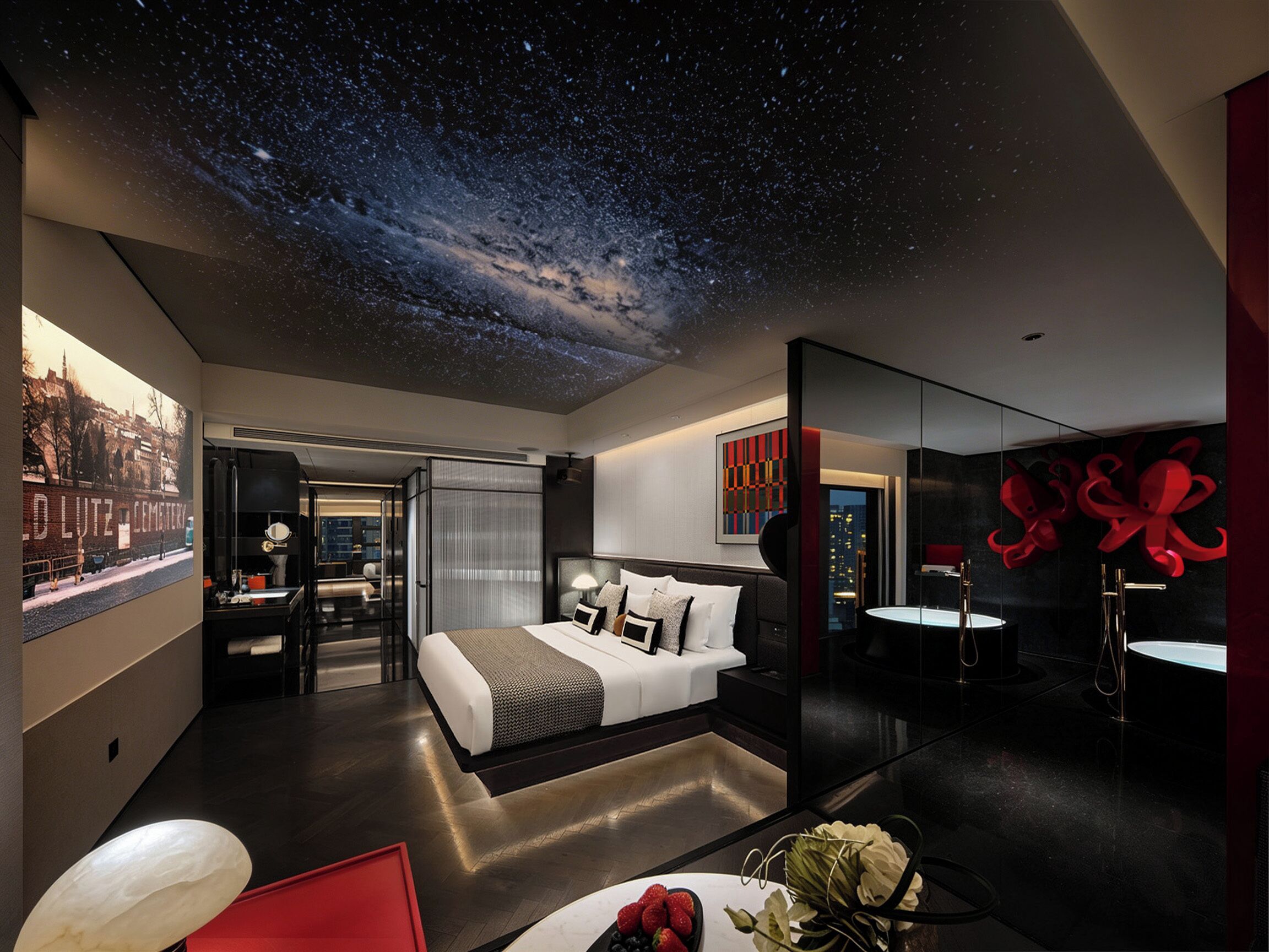 Habitación de hotel moderna con cama, escritorio, espejo y vistas a la ciudad.