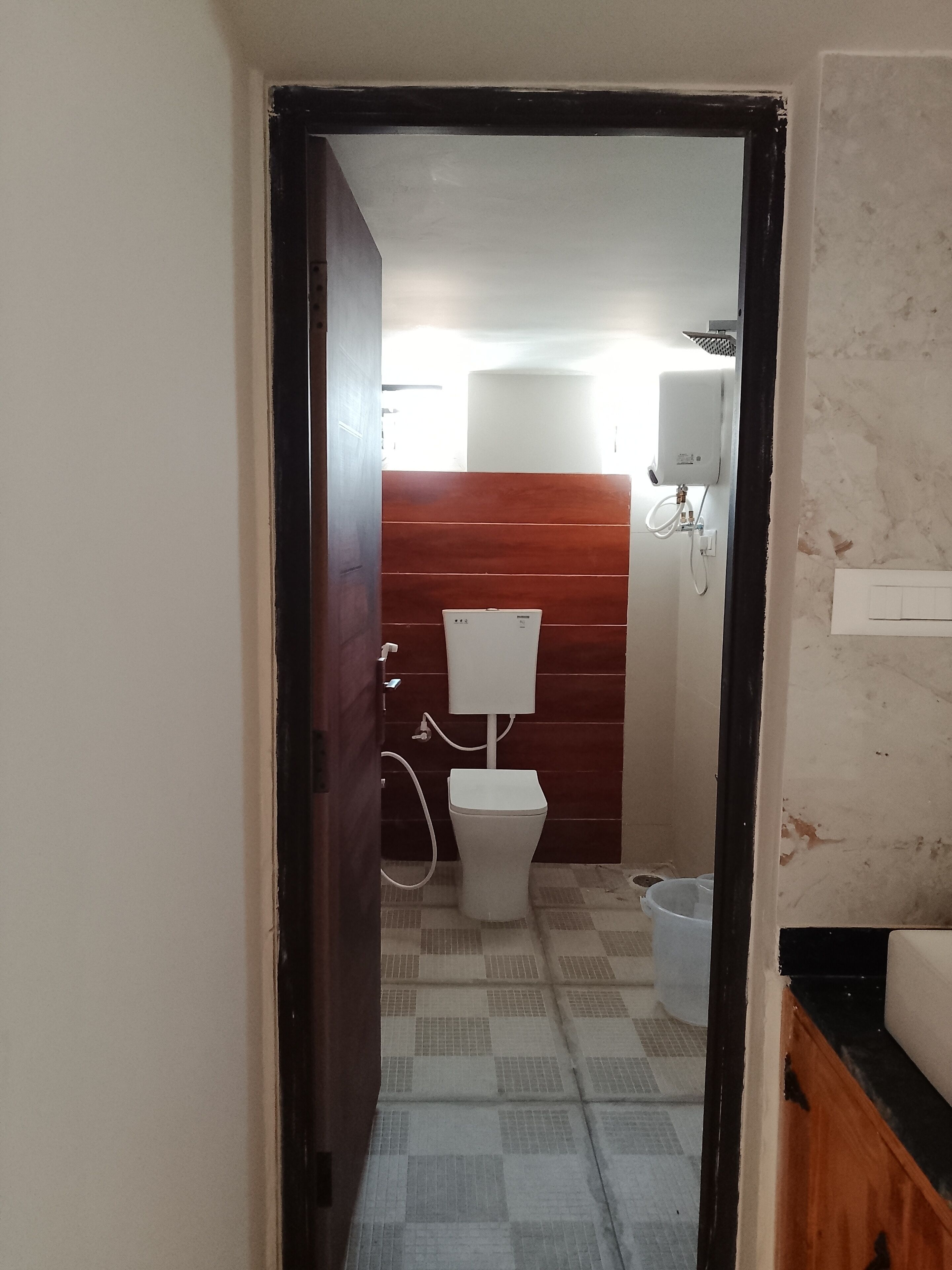 A bathroom with a toilet, a shower, and a water heater.