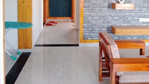 A hallway with a wooden door, a blue accent wall, and a brick wall with shelves. - 2 BHK apartment in Hosapete for a relaxing stay (Hosapete)