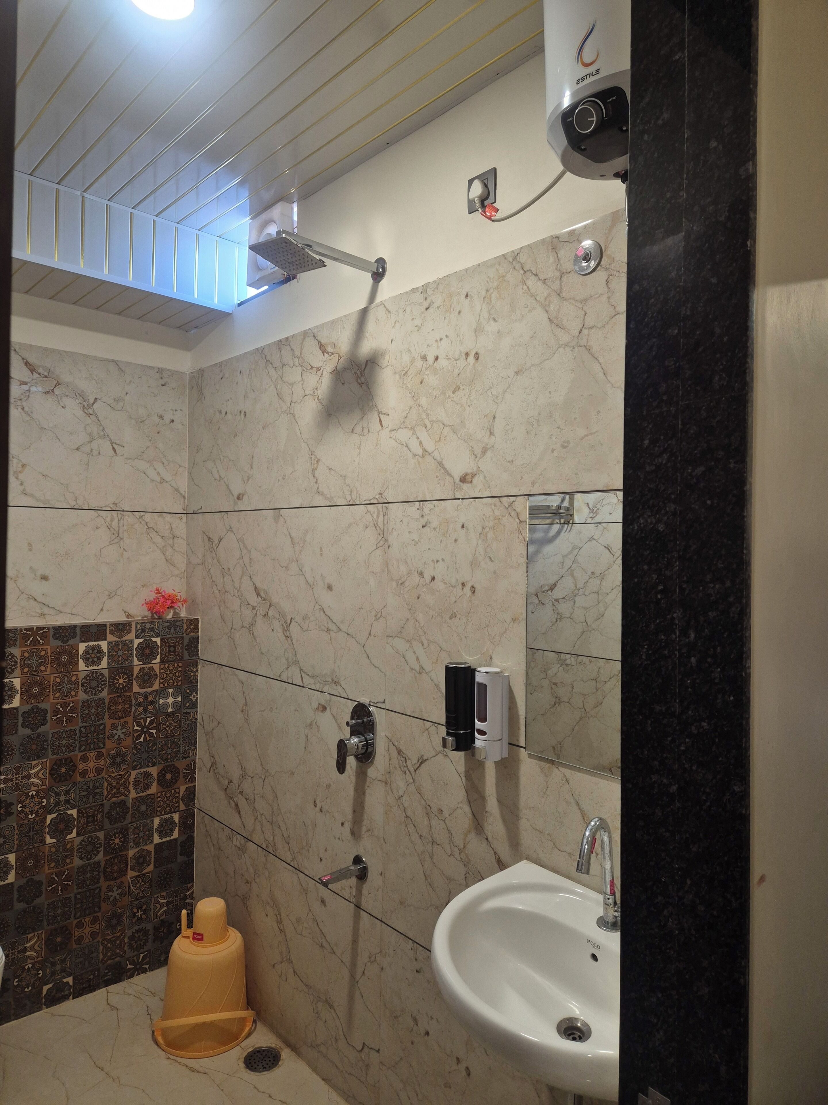 Ein Badezimmer mit Dusche, Waschbecken und Spiegel.