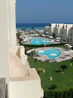 Un complex turístic amb diverses piscines, un jardí ben cuidat i vista a l'oceà.