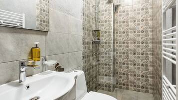 Un baño con lavamanos, inodoro y ducha.