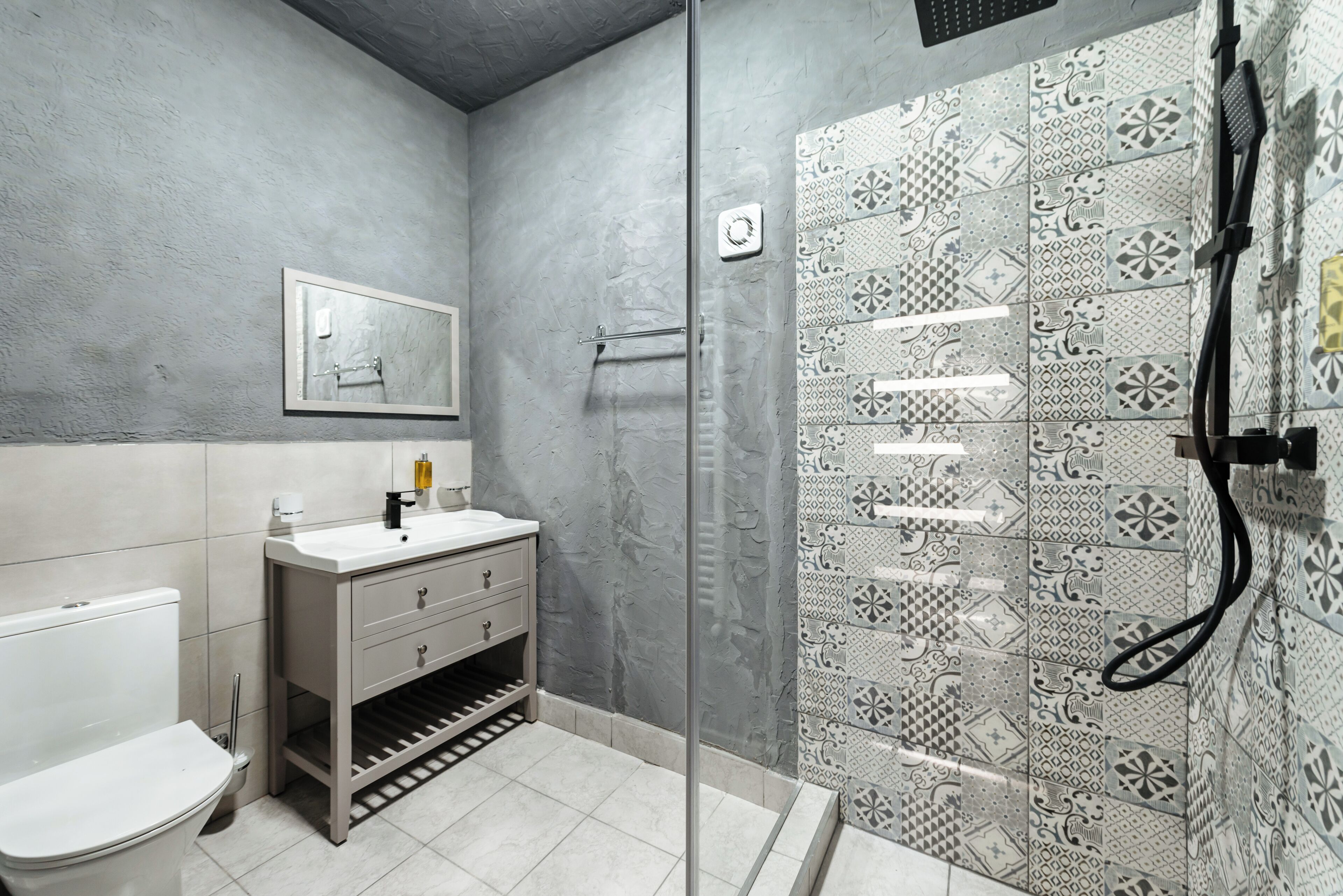 A bathroom with a toilet, sink, and shower.