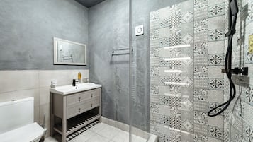 A bathroom with a toilet, sink, and shower.