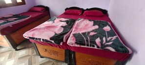 Una habitación con dos camas individuales, cada una con una colcha estampada y almohadas a juego.