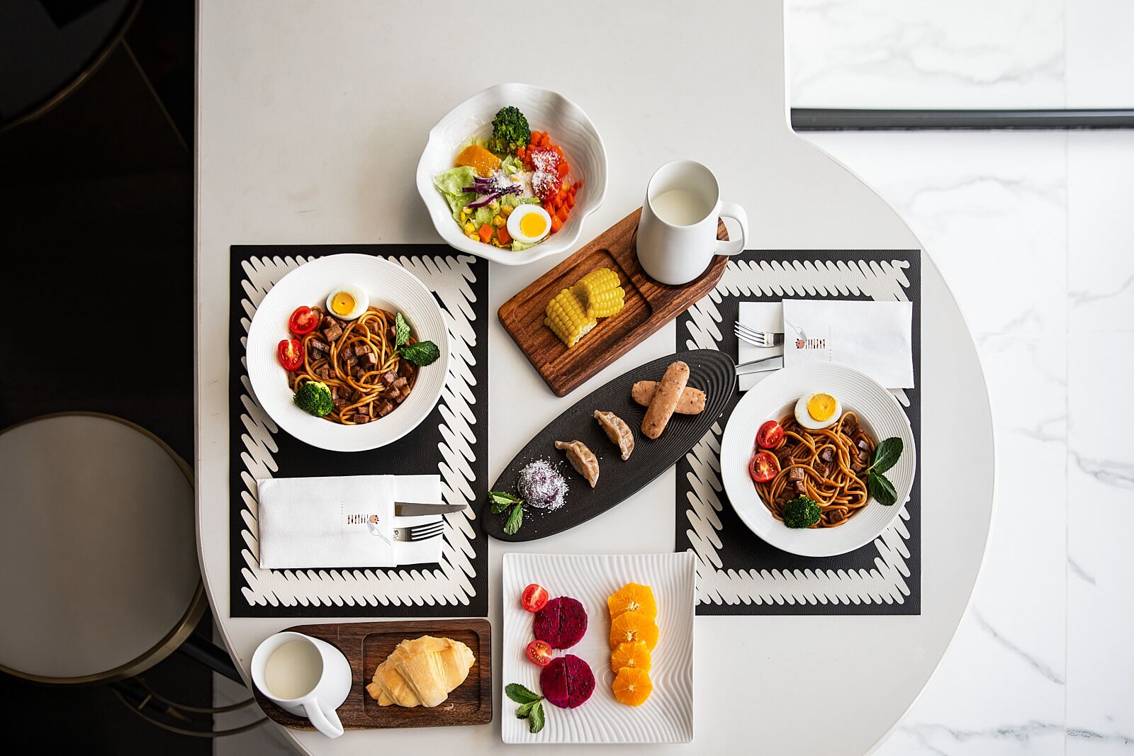 Una mesa de comedor con platos de comida, una taza de café y una servilleta.