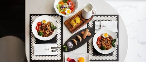 Una mesa de comedor con platos de comida, una taza de café y una servilleta.