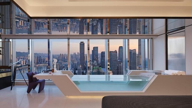 Ein modernes Wohnzimmer mit Blick auf die Stadt, einem Glaspool und einer hohen Decke.
