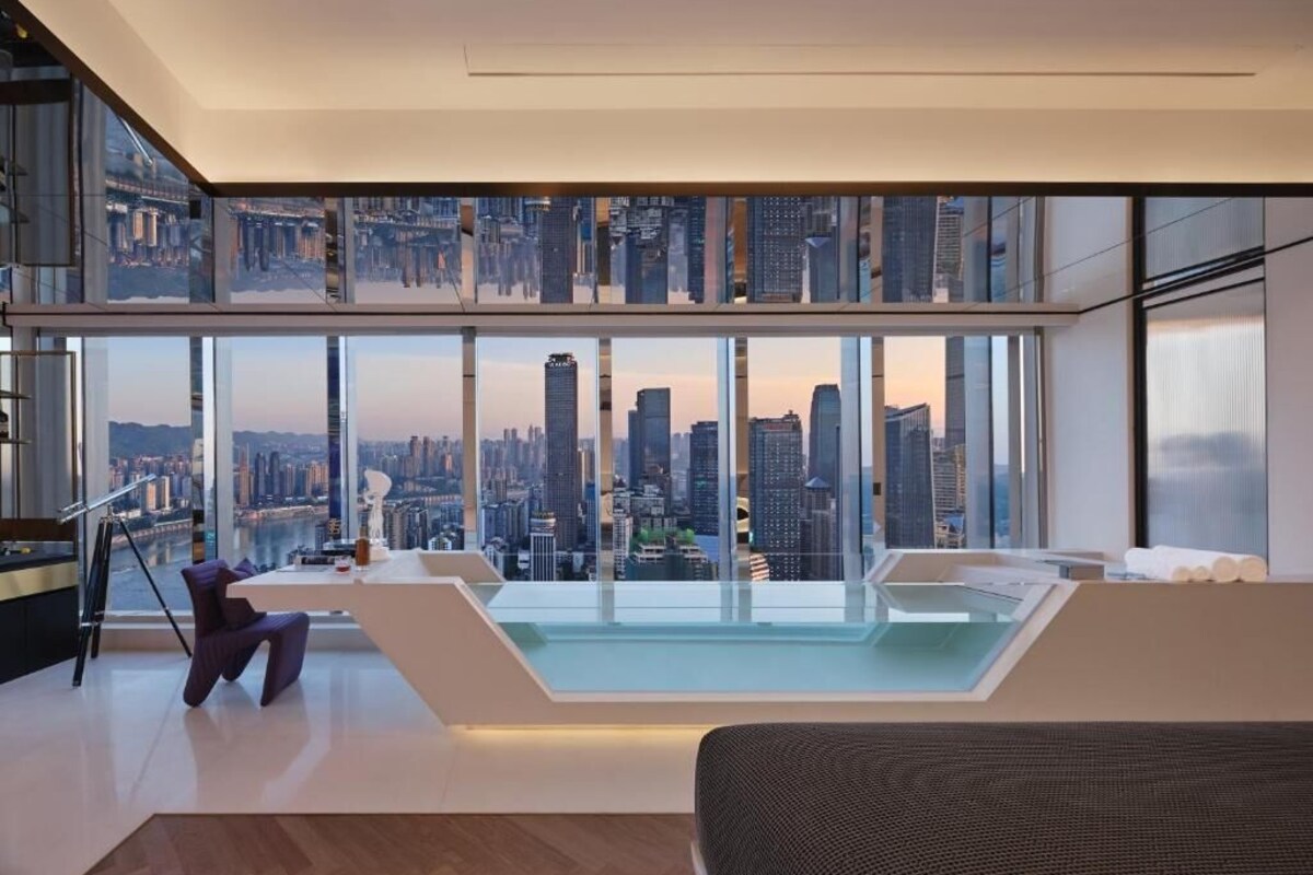 Een moderne woonkamer met uitzicht op de stad, een glazen zwembad en een hoge plafond.