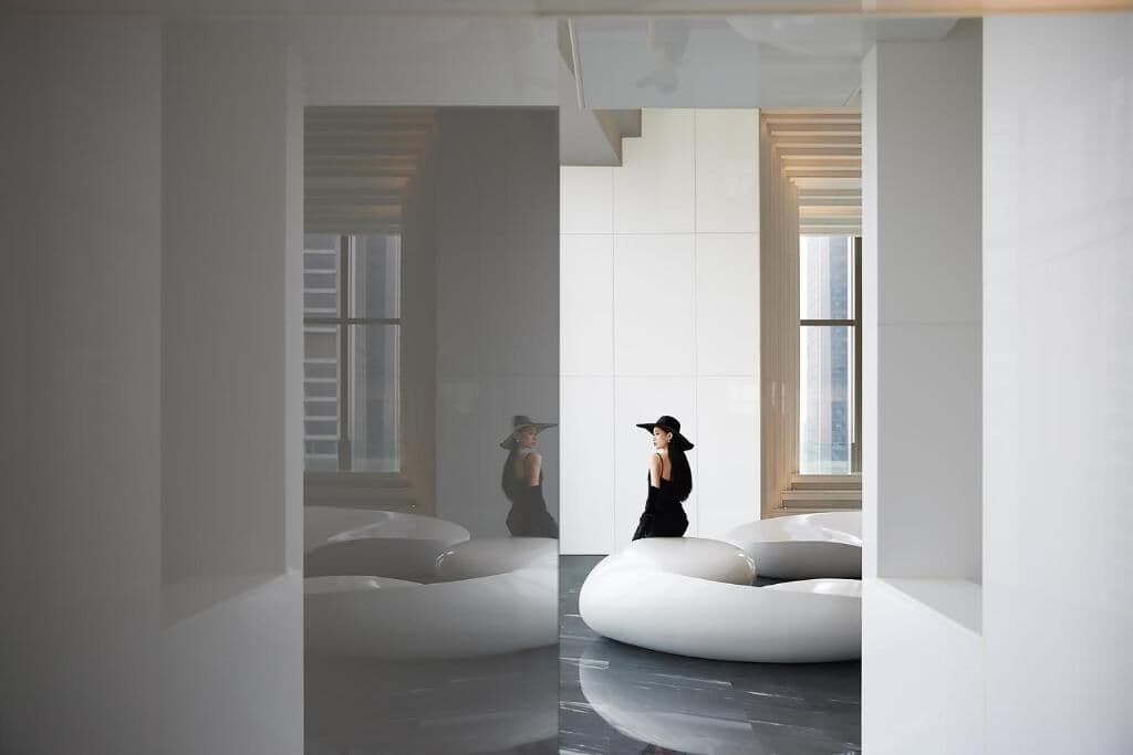 Een modern interieur met een minimalistisch ontwerp, met een centraal zitgedeelte en grote ramen.