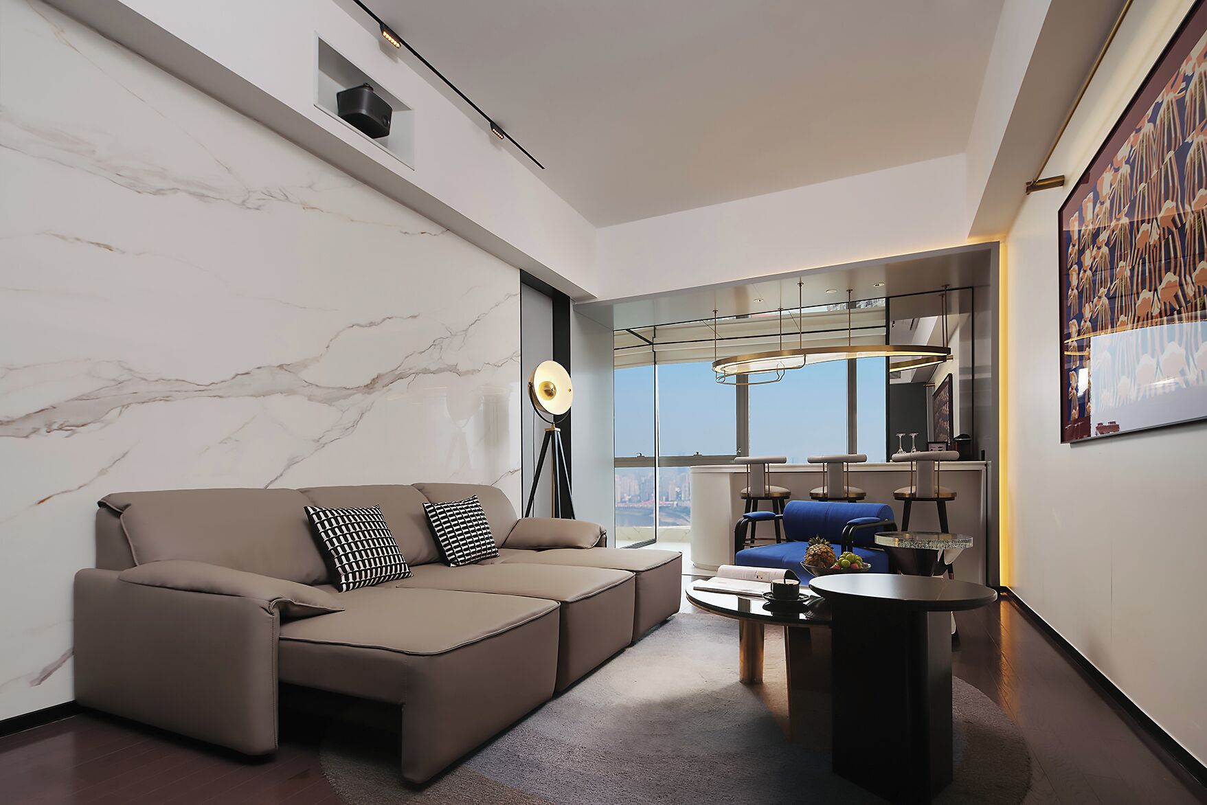 Un salon moderne avec un canapé d’angle, une lampe sur pied, une table basse et une vue sur la ville.
