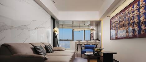 A modern living room with a sofa, a coffee table, and a painting on the wall.