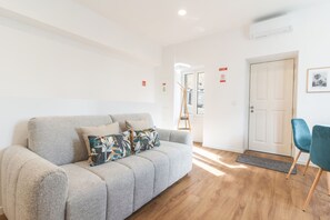 A modern living room with a grey sofa, a teal chair, and a wooden floor. - Chill House by Atlantic Holiday (Funchal)
