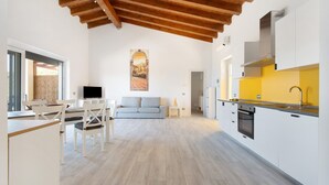 A spacious kitchen with white cabinets, a yellow countertop, and a wooden ceiling. - Adriana Trilocale Apartment with Sea View and Wi-Fi (Lacona)