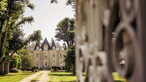 Un imposant bâtiment à la façade symétrique, doté de grandes fenêtres et d’une entrée centrale.