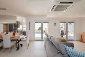 A modern living space with a dining area, a sofa, and a view through the glass doors. - Villa Farini - with private pool near Porec (Farini)