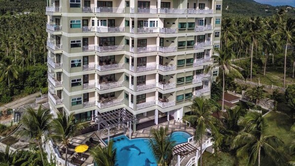 A multi-story hotel with balconies, a swimming pool, and surrounded by palm trees. - Koh Samui Tower (Koh Samui)