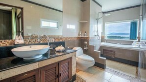 A modern bathroom with a large sink, toilet, and shower.