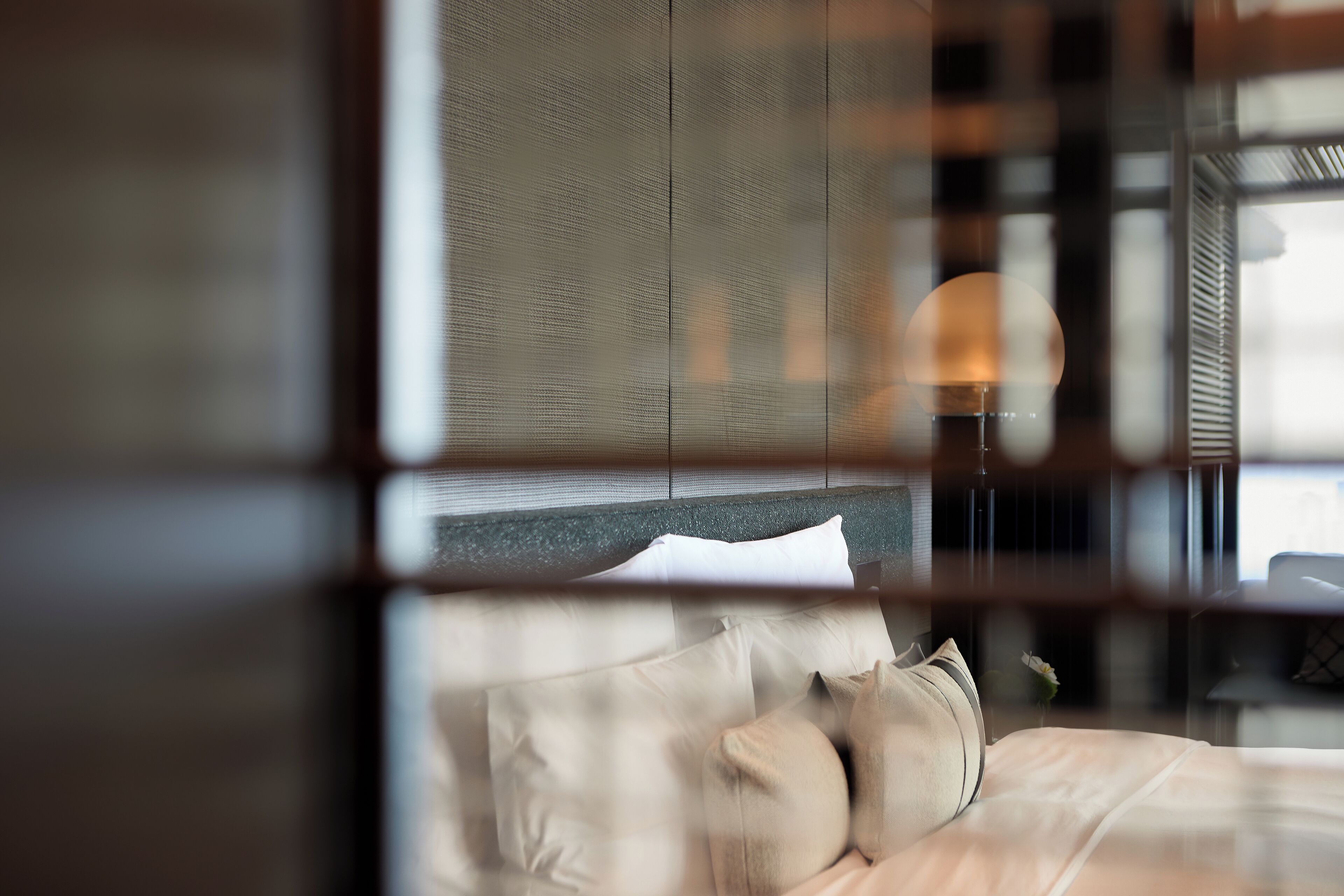 A bedroom with a bed, pillows, and a nightstand.
