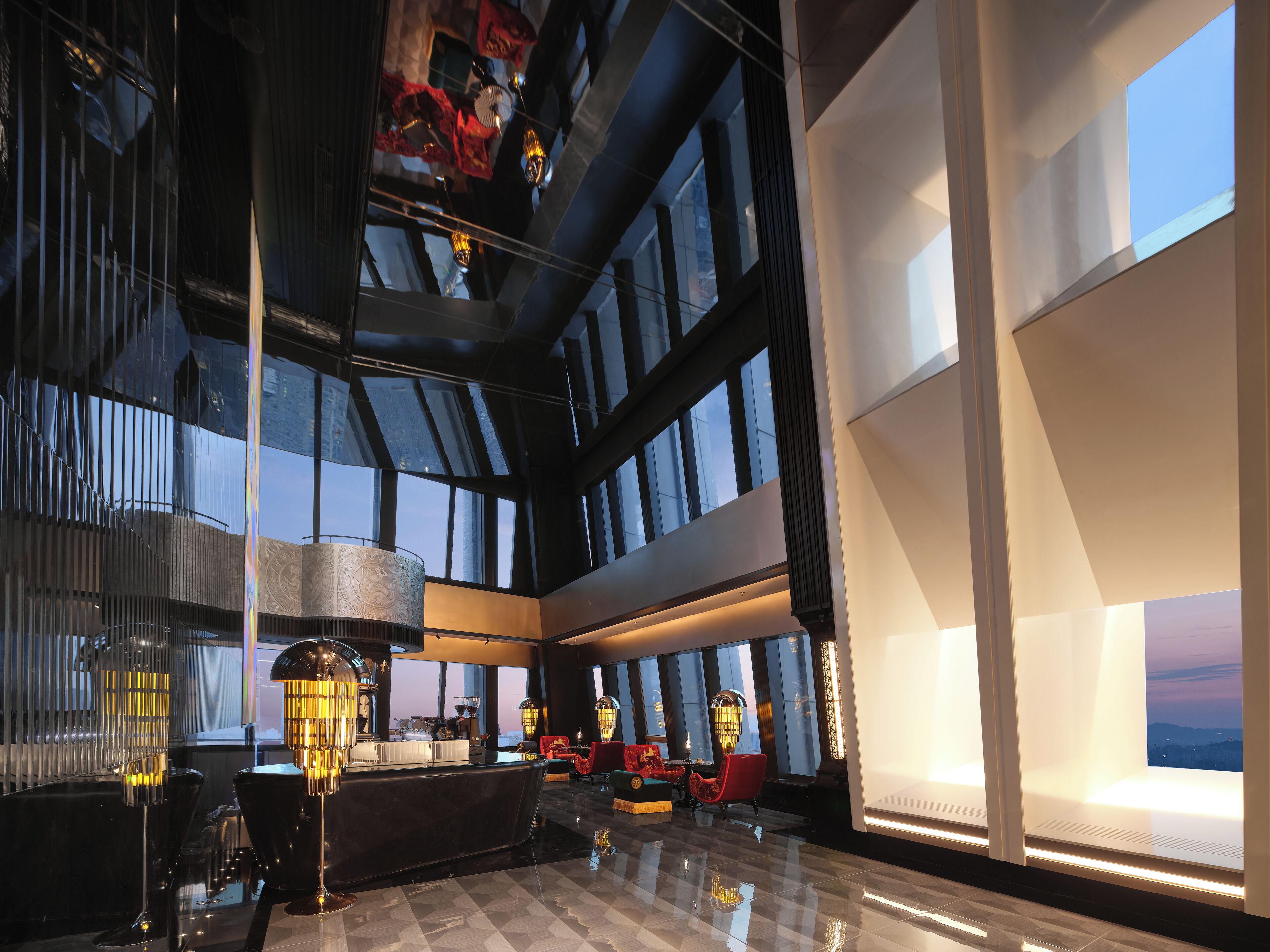 A spacious lobby with a high ceiling, large windows, and modern furnishings.