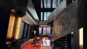 Un intérieur moderne avec un escalier, de grandes fenêtres et une moquette rouge.