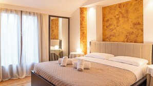 Een moderne hotelkamer met een groot bed, nachtkastje, spiegel en uitzicht op het groen.