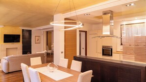 Een moderne keuken met een centraal eiland, een ingebouwde oven en roestvrijstalen apparatuur.