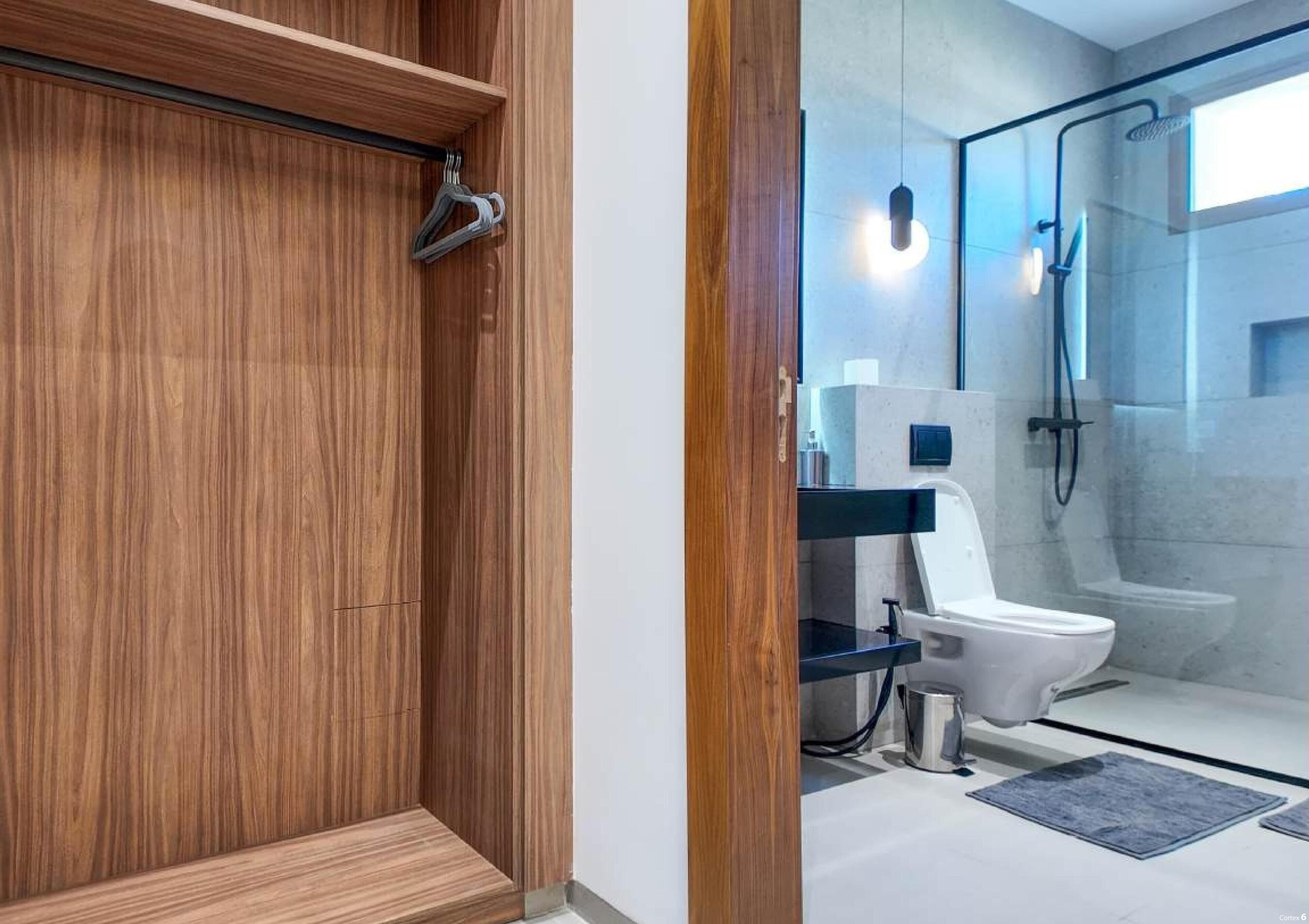 A modern bathroom with a wooden vanity, a glass shower enclosure, and a white toilet.