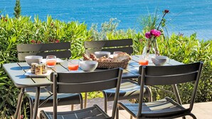 A table set for breakfast with a view of the sea and hills. - Vacation home Babo by Interhome (Porto Vecchio)