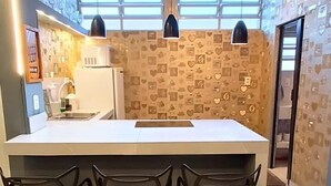 A modern kitchen with a central island, pendant lights, and a heart-patterned backsplash. - 2 bed apart in Asa Sul • Premium Location • Next Esplanada, Lake, Parks, Airport (Brasília)