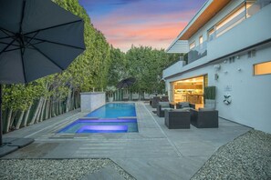 A modern outdoor pool area with a rectangular pool, lounge chairs, and umbrellas. - Colgate Vantage - The House of Views Rooftop Deck & Hollywood Hills Vistas (Los Angeles)