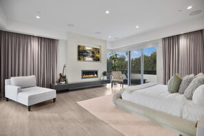 A modern living room with a fireplace, a sofa, a large bed, and a view of the outdoors. - Colgate Vantage - The House of Views Rooftop Deck & Hollywood Hills Vistas (Los Angeles)