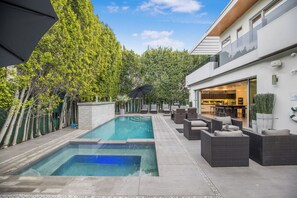 A modern outdoor pool area with a lounge and a building entrance. - Colgate Vantage - The House of Views Rooftop Deck & Hollywood Hills Vistas (Los Angeles)