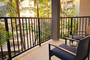 Un balcone con vista su un cortile, una sedia e un tavolo.