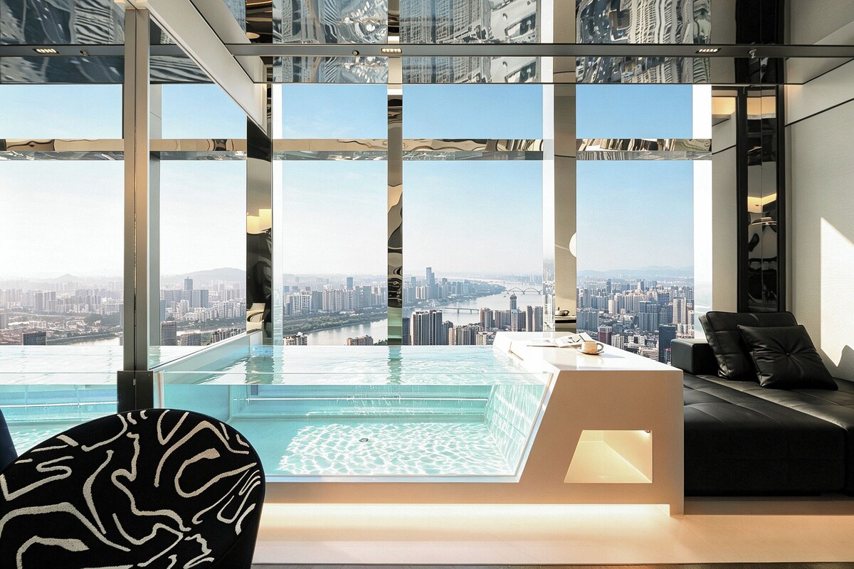 A modern interior with a glass infinity pool, a city view, and a seating area.