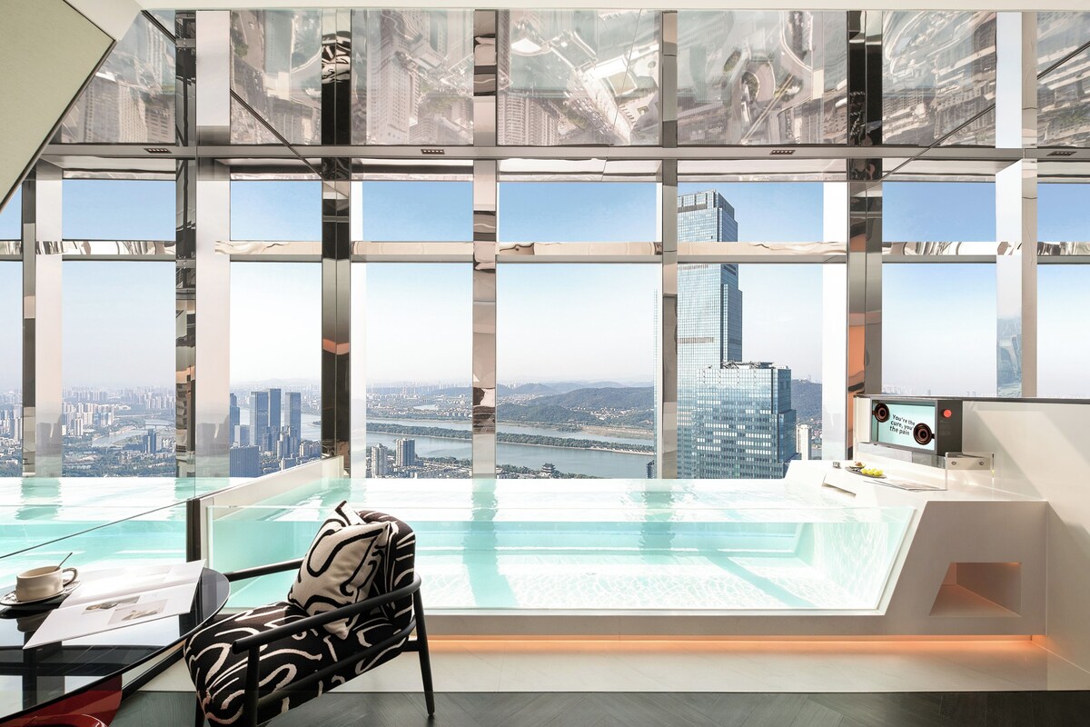 A modern interior with a panoramic view of a cityscape through large windows.