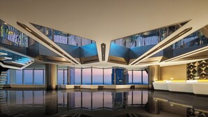 Un moderno vestíbulo de hotel con piso de vidrio, una recepción y vistas a la ciudad.