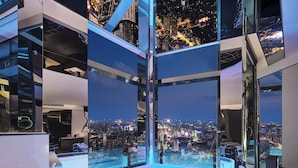Un interior moderno con vistas panorámicas de la ciudad, diseño minimalista y un separador de vidrio.