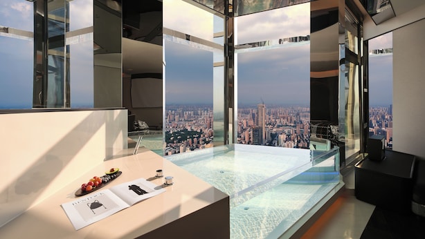 Un interior moderno con una vista panorámica de la ciudad, una mesa de vidrio y un diseño minimalista.