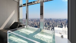 Una habitación moderna con una mesa de vidrio y vista a la ciudad.