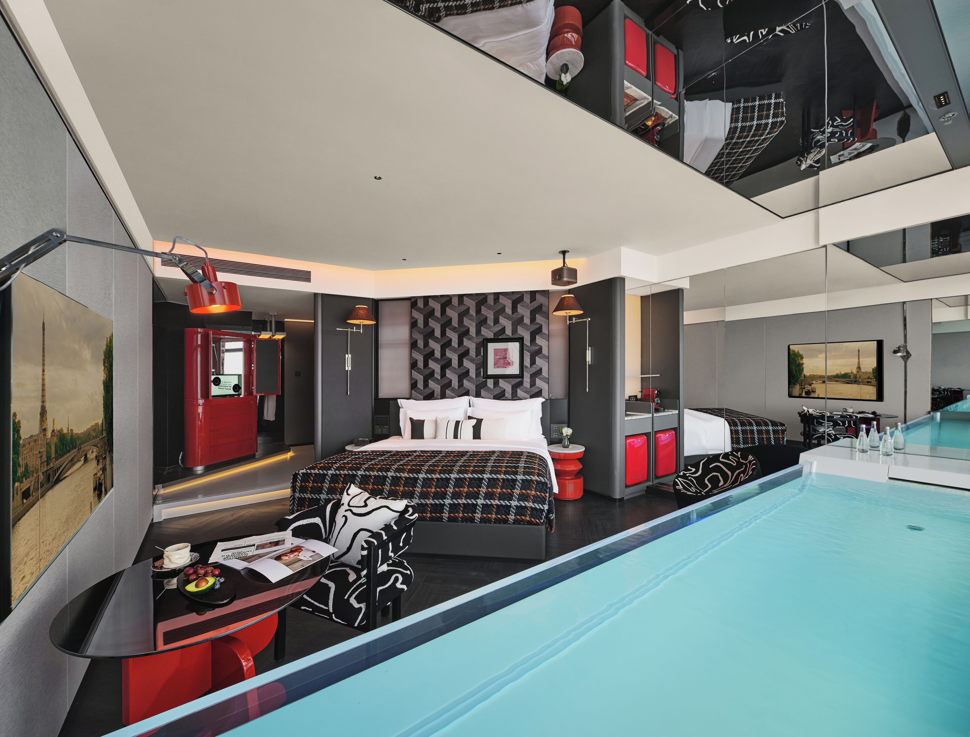 Een moderne hotelkamer met een groot bed, een zwembad en uitzicht op de Eiffeltoren.