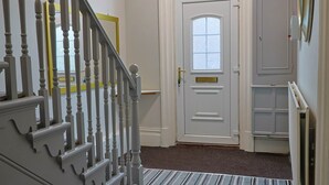 A staircase with a white handrail leading to a door with a window.
