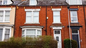 Una hilera de casas adosadas con características arquitectónicas diferenciadas, incluyendo ventanales salientes y diversos estilos de puertas.