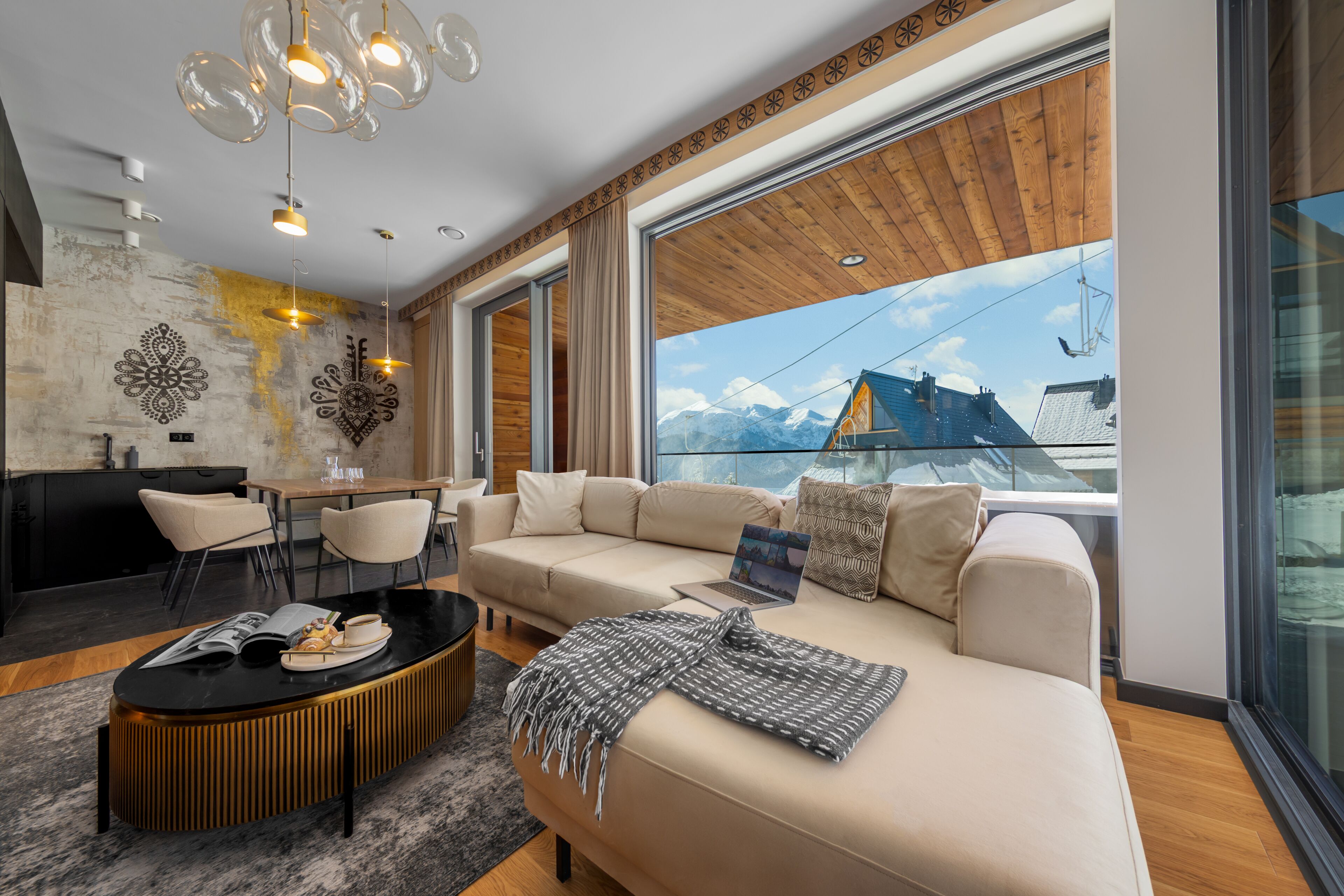 A modern living room with a sofa, coffee table, and dining area.
