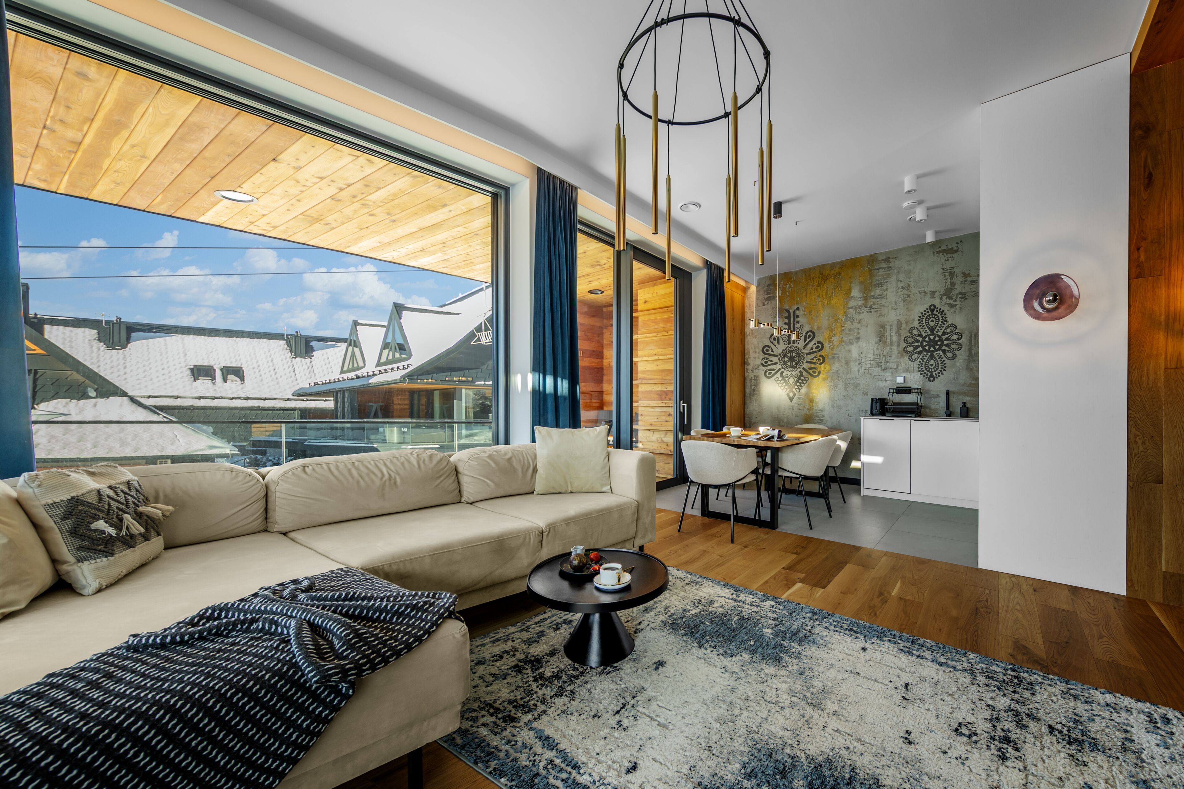 A modern living room with a sofa, coffee table, and dining area.