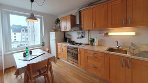 Una cocina moderna con armarios de madera, horno empotrado y ventana con vistas a la ciudad.